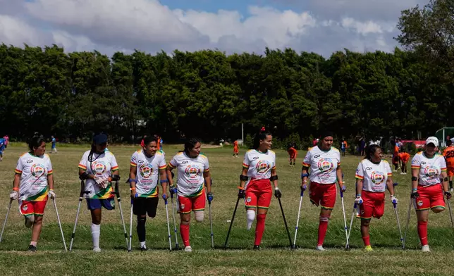 Palyers stand on the field prior to playing during a women's amputee soccer clinic in Santa Cruz, Bolivia, Friday, July 17, 2026. (AP Photo/Juan Karita)