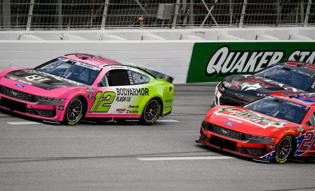 Ryan Blaney (12) and Joey Logano (22) run during a NASCAR Cup Series auto race, Sunday, July 12, 2026, in Hampton, Ga. (AP Photo/Mike Stewart)
