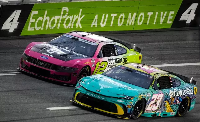 Bubba Wallace (23) and Ryan Blaney (12) move on the track during a NASCAR Cup Series auto race, Sunday, July 12, 2026, in Hampton, Ga. (AP Photo/Mike Stewart)