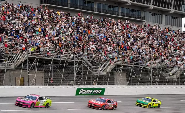 Ryan Blaney, Joey Logano, and Austin Cindric, from left, run during a NASCAR Cup Series auto race, Sunday, July 12, 2026, in Hampton, Ga. (AP Photo/Mike Stewart)