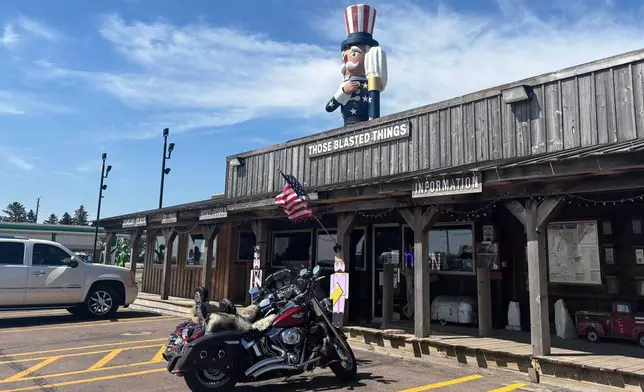 Verne the Patriot rises behind the shop Those Blasted Things in Luverne, Minn., Saturday, July 18, 2026. (AP Photo/Sarah Raza)