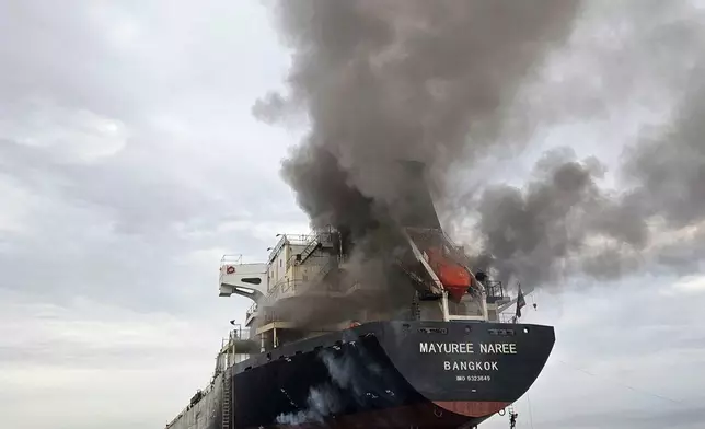 Smoke billows from the Mayuree Naree, a Thailand-flagged bulk carrier, after it was hit by a projectile in the Strait of Hormuz, north of Oman, on March 11, 2026. (Panithi Tumkaew via AP)