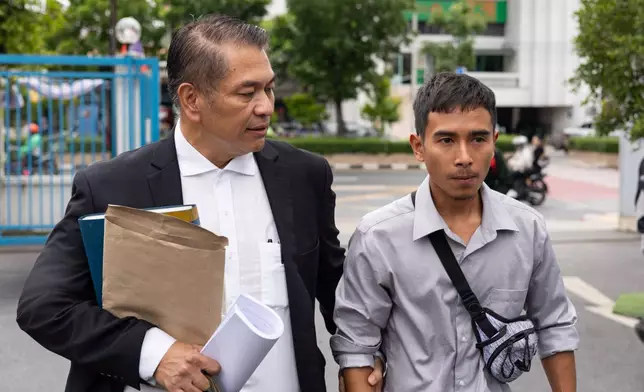 Lawyer Kunpat Singhathong and Noppadon Wongsuvan, a former sailor from the Thailand-flagged ship, the Mayuree Naree, walk towards the Central Labour Court in Bangkok, Thailand on Friday, July 10, 2026. (AP Photo/Anton L. Delgado)
