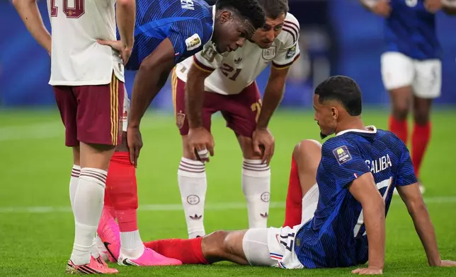 France's William Saliba (17) is checked on by France's Aurelien Tchouameni (8) and Spain's Mikel Oyarzabal (21) after being injured during the World Cup semifinal soccer match between France and Spain in Arlington, Texas, near Dallas, Tuesday, July 14, 2026. (AP Photo/Eric Gay)