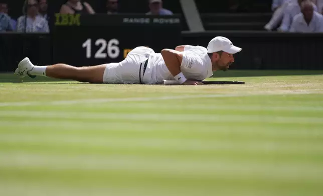Novak Djokovic of Serbia falls over during a point against Roman Saffiulin of Russia in their fourth round men's singles match at the Wimbledon Tennis Championships in London, Sunday, July 5, 2026. (AP Photo/Brian Inganga)