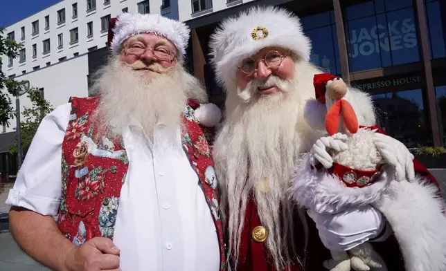 Robert Hercz, a 64-year-old Santa Claus performer from Oslo, Norway, right, pose with an unidentified Santa Claus performer for a photo at the annual World Santa Claus Congress, a colorful midsummer tradition, in Aalborg, Denmark, Wednesday July 8, 2026. (AP Photo/James Brooks)