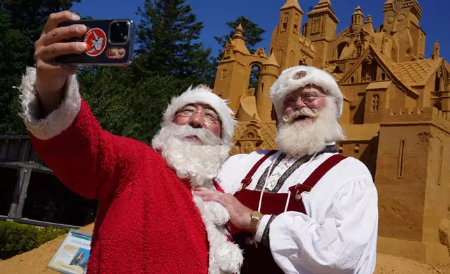 Paradise Yamamoto, a Santa Claus performer from Tokyo, left, and Peter Gislund, a 57-year-old Santa Claus performer from Aalborg, take a selfie during the annual World Santa Claus Congress, a colorful midsummer tradition, in Aalborg, Denmark, Wednesday July 8, 2026. (AP Photo/James Brooks)