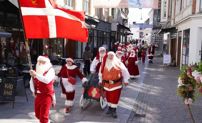 Santas, Mrs. Clauses and Christmas elves from around the world take part in a parade through the streets of Aalborg Denmark, Wednesday July 8, 2026 during the annual World Santa Claus Congress. (AP Photo/James Brooks)