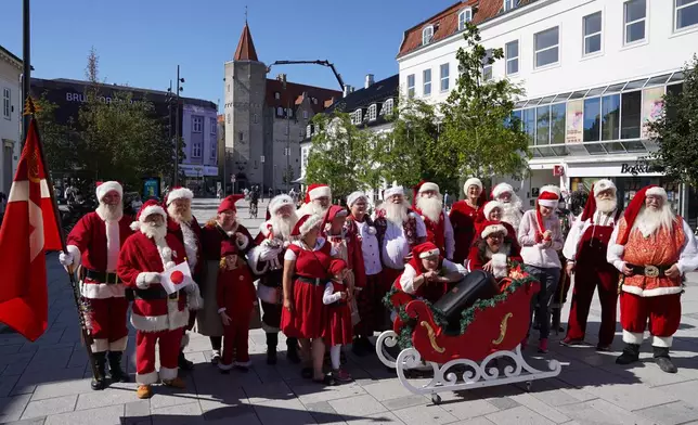 Santas, Mrs. Clauses and Christmas elves from around the world pose for a photo at the annual World Santa Claus Congress, a colorful midsummer tradition, in Aalborg, Denmark, Wednesday July 8, 2026. (AP Photo/James Brooks)