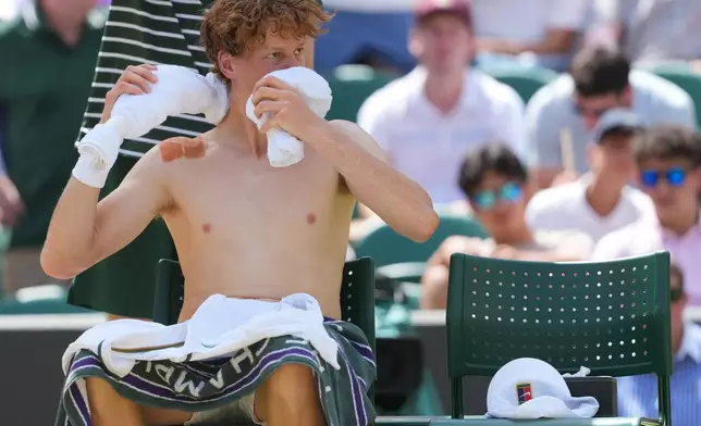 Jannik Sinner of Italy wraps an ice towel around his neck as he rests after winning the first set against Jan-Lennard Struff of Germany in their quarter-final men's singles match at the Wimbledon Tennis Championships in London, Tuesday, July 7, 2026. (AP Photo/Kin Cheung)