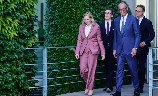 Chancellor Friedrich Merz, second from right, arrives with Nina Warken, left, Philipp Amthor, second from left, and Carsten Linnemann, right, for statement about planned personnel changes in his government at the chancellery in Berlin, Germany, Friday, July 24, 2026. (AP Photo/Markus Schreiber)