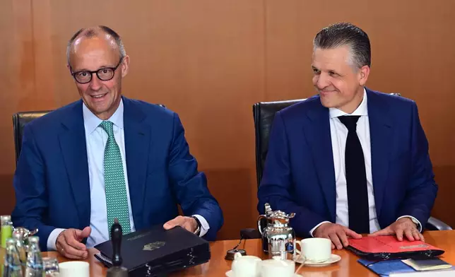 German Chancellor Friedrich Merz, left, and Thorsten Frei, Head of the Federal Chancellery and Federal Minister for Special Tasks attend the cabinet meeting at the chancellery in Berlin, Germany, Wednesday, July 22, 2026. (Sebastian Gollnow/dpa via AP)