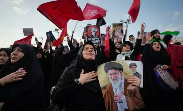 A mourner reacts while holding a portrait of the slain Iranian Supreme Leader Ayatollah Ali Khamenei as mourners gather in Islamic Revolution Square for Khamenei's funeral procession in Tehran, Iran, Monday, July 6, 2026. (AP Photo/Altaf Qadri)