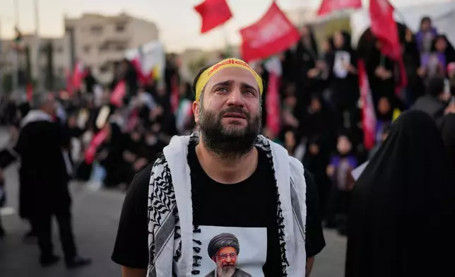 A mourner wearing a shirt depicting the slain Iranian Supreme Leader Ayatollah Ali Khamenei weeps while gathered in Islamic Revolution Square for Khamenei's funeral procession in Tehran, Iran, Monday, July 6, 2026. (AP Photo/Altaf Qadri)
