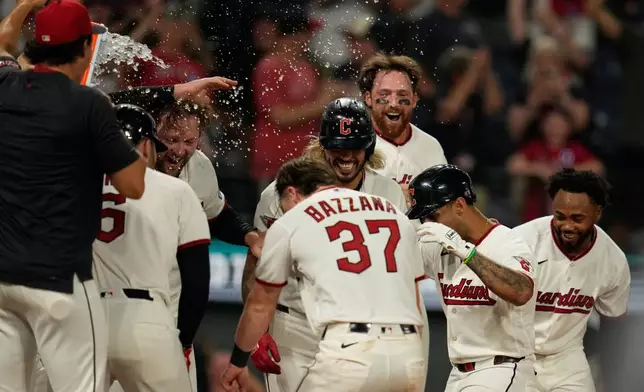 Cleveland Guardians' Brayan Rocchio, second from right, is mobbed by teammates as he runs to home plate after hitting a game winning home rum in the ninth inning of a baseball game against the Chicago White Sox in Cleveland, Thursday, July 2, 2026. (AP Photo/Sue Ogrocki)