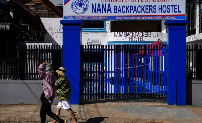 FILE -Foreign tourists walk past the closed Nana Backpackers hostel in Vang Vieng, Laos, Nov. 23, 2024. (AP Photo/Anupam Nath, File)
