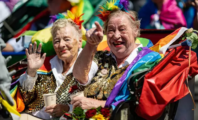 People wave during the Christopher Street Day parade in Berlin, on Saturday, July 25, 2026. (Fabian Sommer/dpa via AP)