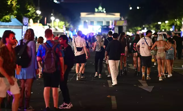 People stand on 17 June Street following the cancellation of Christopher Street Day in Berlin, on Saturday, July 25, 2026. (Fabian Sommer/dpa via AP)