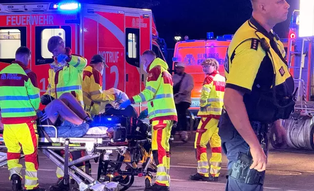 Emergency personnel tend to a person on a stretcher following the cancellation of Christopher Street Day in Berlin on Saturday, July 25, 2026. (Andreas Rabenstein/dpa via AP)