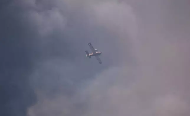 A water bomber flies over a wildfire in Ille-sur-Têt, southern France, Monday, July 6, 2026. (AP Photo/Thibault Camus)