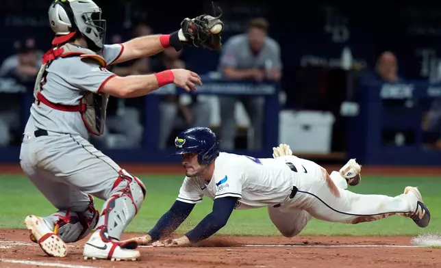 Tampa Bay Rays' Nick Fortes, right, scores ahead of the tag by Cleveland Guardians catcher Austin Hedges on an RBI single by Junior Caminero during the sixth inning of a baseball game Friday, July 24, 2026, in St. Petersburg, Fla. (AP Photo/Chris O'Meara)
