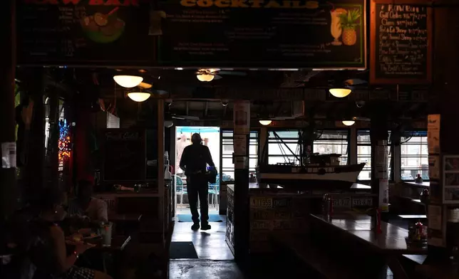 A Haitian worker with Temporary Protected Status busses tables at Half Shell Raw Bar, Friday, July 24, 2026, in Key West, Fla.(AP Photo/Rebecca Blackwell)