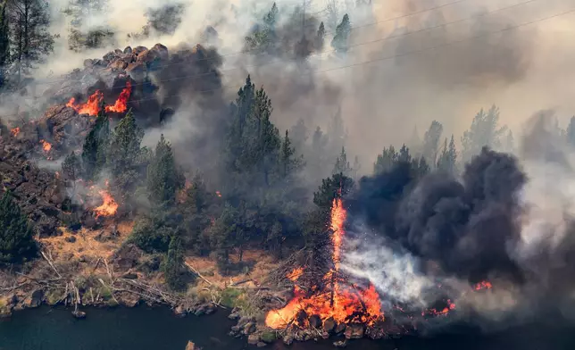 The Bench fire burns along the banks of the Deschutes River on Saturday, July 25, 2026, in Jefferson County, Ore. (AP Photo/Noah Berger)