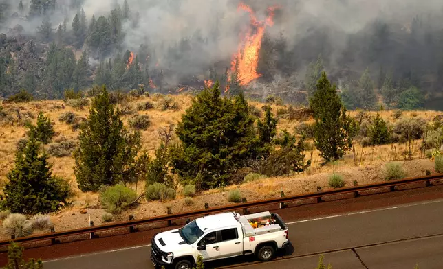 The Bench fire burns along the banks of the Deschutes River on Saturday, July 25, 2026, in Jefferson County, Ore. (AP Photo/Noah Berger)