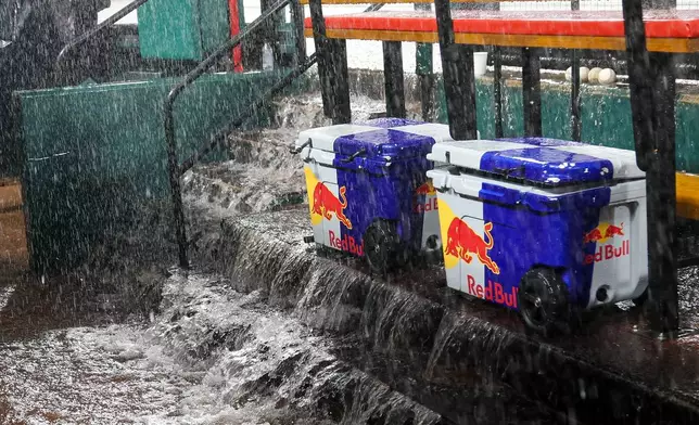 Water flows down the steps into the dugout during a rain delay in the fourth inning of a baseball game between the St. Louis Cardinals and the Atlanta Braves Friday, July 10, 2026, in St. Louis. (AP Photo/Scott Kane)