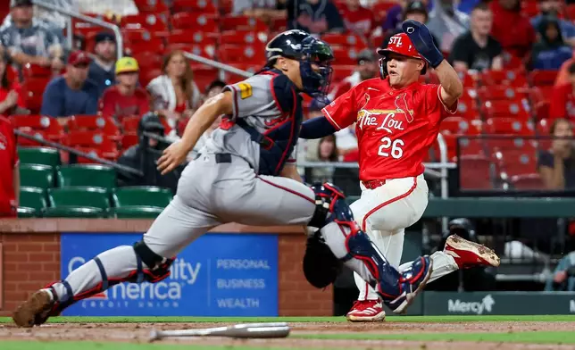 St. Louis Cardinals' JJ Wetherholt (26) scores a run ahead of the throw to Atlanta Braves' Drake Baldwin during the sixth inning of a baseball game Friday, July 10, 2026, in St. Louis. (AP Photo/Scott Kane)