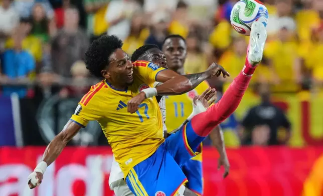 Colombia's Johan Mojica (17) kicks the ball over Ghana's Inaki Williams for the ball during the World Cup round of 32 soccer match between Colombia and Ghana in Kansas City, Mo., Friday, July 3, 2026. (AP Photo/Ed Zurga)