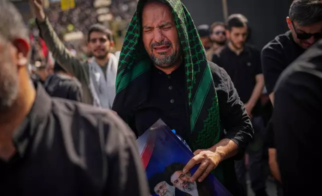 A mourner weeps as he attends the start of the dayslong funeral ceremonies for slain Iranian Supreme Leader Ayatollah Ali Khamenei and members of his family at the Imam Khomeini Mosalla Grand Mosque in Tehran, Iran, Saturday, July 4, 2026. (AP Photo/Altaf Qadri)