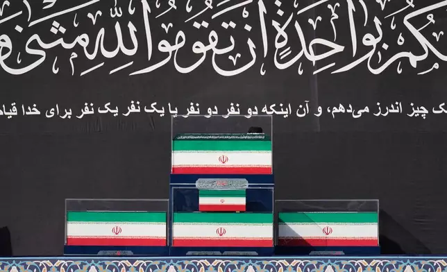 The coffins of slain Iranian Supreme Leader Ayatollah Ali Khamenei and members of his family are displayed on a platform at the start of the dayslong funeral ceremonies at the Imam Khomeini Mosalla Grand Mosque in Tehran, Iran, Saturday, July 4, 2026. (AP Photo/Altaf Qadri)