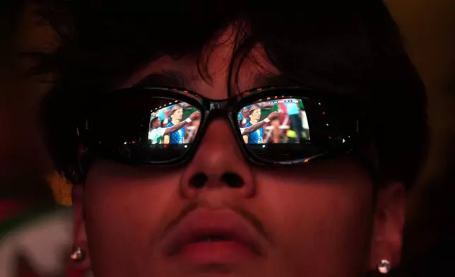 Croatia's team captain Luka Modric is reflected on the glasses of a Portugal fan watching on a big screen in Lisbon, Portugal, the World Cup round of 32 soccer match between Portugal and Croatia, Friday, July 3, 2026. (AP Photo/Armando Franca)