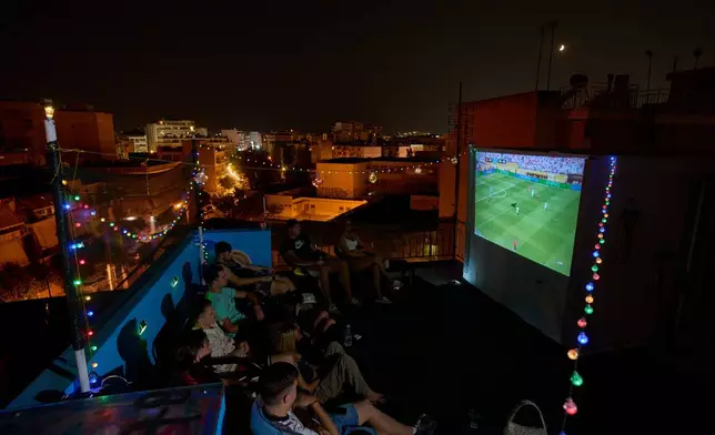 People watch a live projection of the World Cup final soccer match between Spain and Argentina on a rooftop in Tavros, suburb of Athens, Greece, Sunday, June 19, 2026. (AP Photo/Petros Giannakouris)