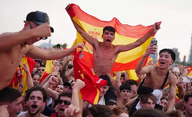 Spanish fans cheer for their team while watching the World Cup final soccer match between Spain and Argentina on giant screens in Barcelona, Sunday, July 19, 2026. The match is being played in East Rutherford, N.J., near New York. (AP Photo/Joan Mateu Parra)