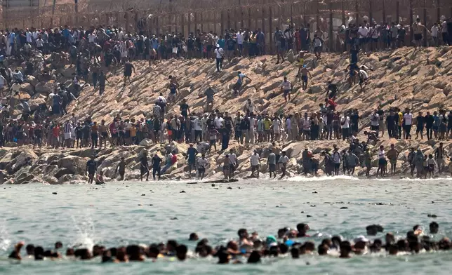 Migrants cross from Morocco into the Spanish enclave of Ceuta, Thursday, July 30, 2026. (AP Photo/Antonio Sempere)
