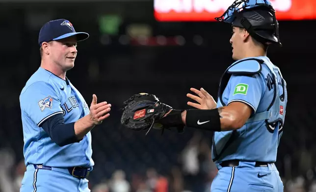 Toronto Blue Jays closing pitcher Louis Varland, left, is congratulated by Blue Jays catcher Brandon Valenzuela after getting a save during the ninth inning of a baseball game against the Washington Nationals, Monday, July 27, 2026, in Washington. (AP Photo/John McDonnell)