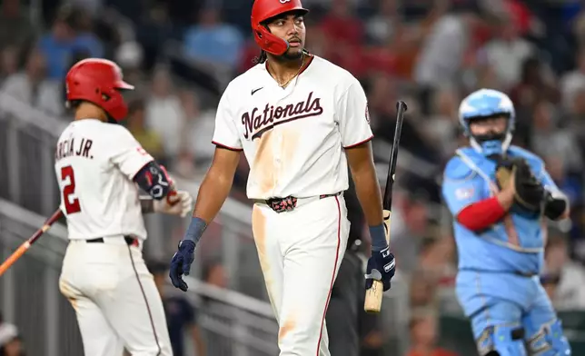 Washington Nationals' James Wood, center, walks back to the dugout after striking out during the seventh inning of a baseball game against the Toronto Blue Jays, Monday, July 27, 2026, in Washington. (AP Photo/John McDonnell)