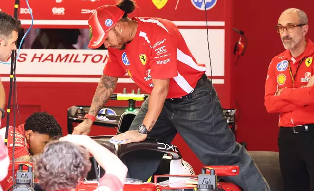 Ferrari driver Lewis Hamilton of Britain steps into his car in the team garage ahead of the Formula One Grand Prix at the Spa-Francorchamps racetrack in Spa, Belgium, Thursday, July 16, 2026. (AP Photo/Omar Havana)