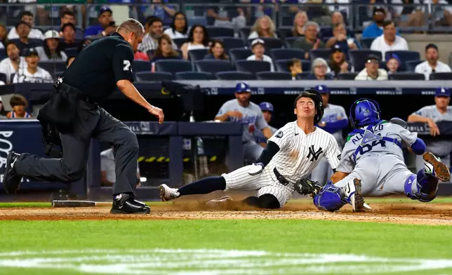 New York Yankees' Anthony Volpe, center, is tagged out by Los Angeles Dodgers catcher Eliezer Alfonzo, right, during the fourth inning of the second game of a baseball doubleheader, Sunday, July 19, 2026, in New York. (AP Photo/Noah K. Murray)