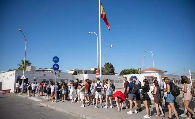 People queue to cross the border between Spain and Gibraltar, in La Linea de la Concepcion, Spain, Monday, July 6, 2026. (AP Photo/Marcos Moreno)