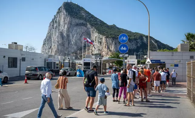 People queue to cross the border between Spain and Gibraltar, in La Linea de la Concepcion, Spain, Monday, July 6, 2026. (AP Photo/Marcos Moreno)