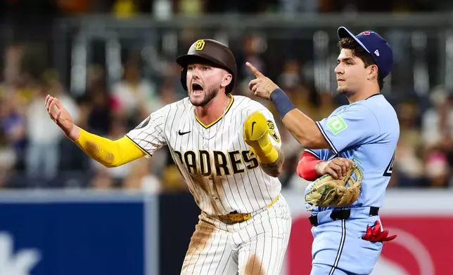 San Diego Padres' Jackson Merrill, left, reacts after the team challenged the out call on an attempted steal at second base as Toronto Blue Jays' Luis Urías looks on in the eighth inning of a baseball game Saturday, July 11, 2026, in San Diego. (AP Photo/Derrick Tuskan)