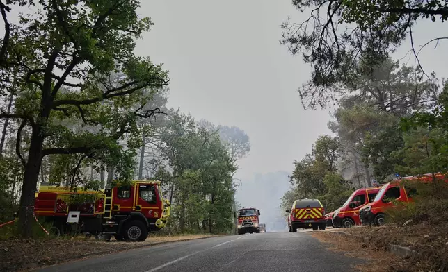 Fire trucks are parked near the scene of a wildfire in the region of the historic Fontainebleau forest, about 60 km (37 miles) south of Paris, France, Monday, July 13, 2026. (AP Photo/Emma Da Silva)