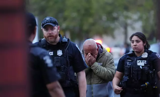 An unidentified man is led into the scene by police after they responded to a shooting at Seattle Center during the Bite of Seattle food festival Sunday, July 26, 2026, in Seattle, Wash. (AP Photo/Lindsey Wasson)