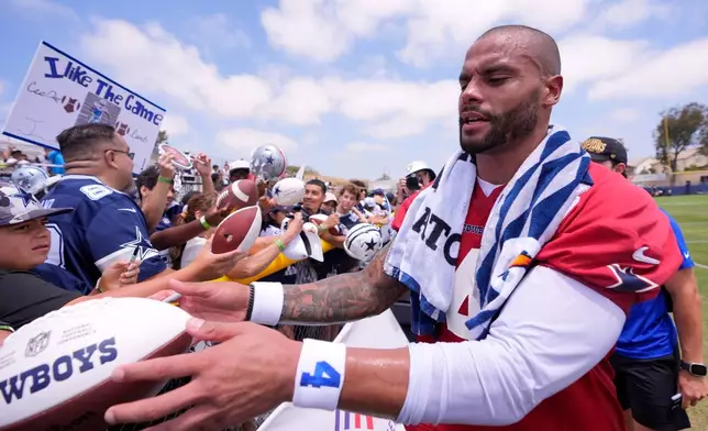 Dallas Cowboys quarterback Dak Prescott signs autographs during the NFL football team's training camp, Wednesday, July 29, 2026, in Oxnard, Calif. (AP Photo/Mark J. Terrill)