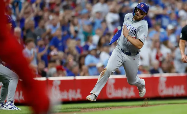 Chicago Cubs' Michael Busch runs to score from first base on a hit by teammate Ian Happ during the sixth inning of a baseball game against the Cincinnati Reds, Saturday, July 11, 2026, in Cincinnati. (AP Photo/Jay LaPrete)