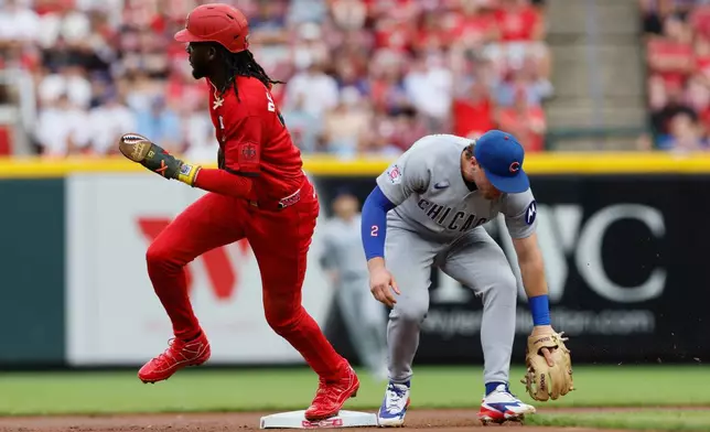 Cincinnati Reds' Jose De La Cruz, left, runs past Chicago Cubs second baseman Nico Hoerner, right, on a missed ball during the first inning of a baseball game, Saturday, July 11, 2026, in Cincinnati. (AP Photo/Jay LaPrete)