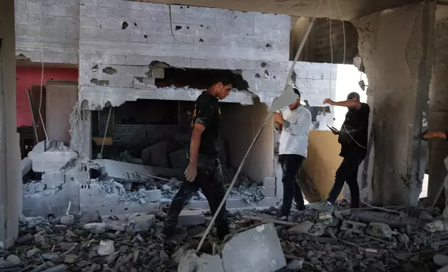 Residents inspect the site of an Israeli airstrike in Gaza city, Saturday, July 18, 2026. (AP Photo/Jehad Alshrafi)